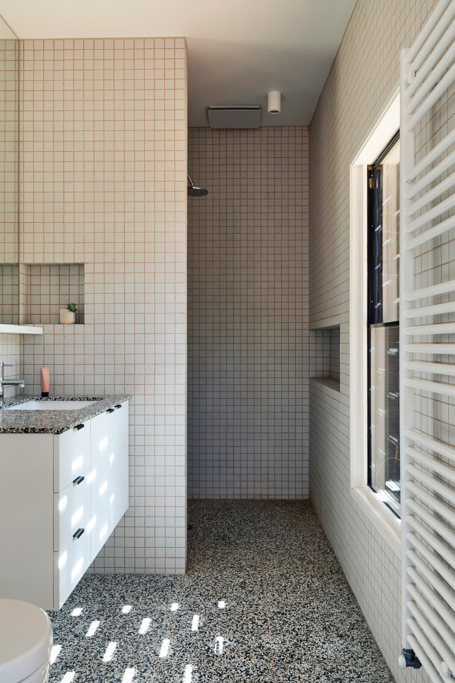 Inspiration for a midcentury bathroom in Melbourne with flat-panel cabinets, white cabinets, a built-in shower, beige tiles, mosaic tiles, beige walls, mosaic tile flooring, a submerged sink, grey floors, an open shower, grey worktops, a wall niche, a single sink and a floating vanity unit.