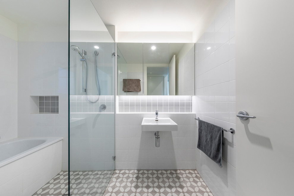 Small scandi family bathroom in Canberra - Queanbeyan with a built-in bath, a walk-in shower, white tiles, ceramic tiles, white walls, cement flooring, a wall-mounted sink, a wall niche, a single sink and a floating vanity unit.