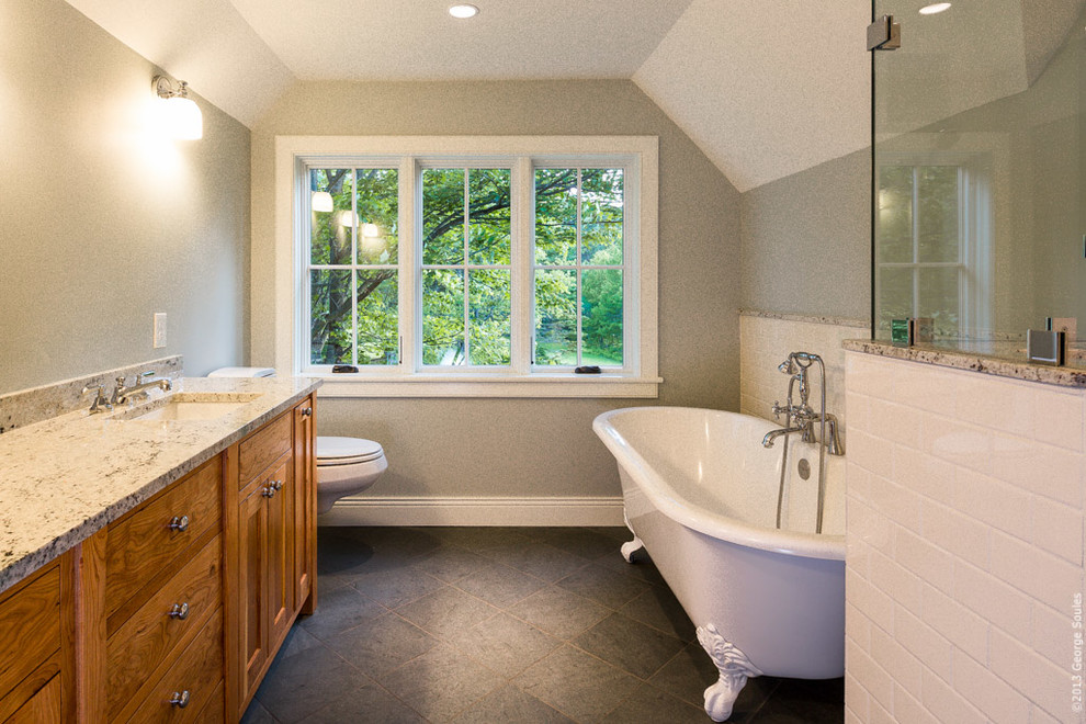 Imagen de cuarto de baño campestre con lavabo bajoencimera, armarios tipo mueble, puertas de armario de madera oscura y encimera de granito