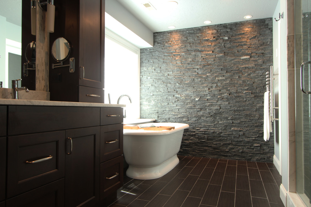 Photo of a medium sized traditional ensuite bathroom in Other with flat-panel cabinets, dark wood cabinets, a freestanding bath, an alcove shower, a two-piece toilet, grey tiles, stone tiles, grey walls, slate flooring, a built-in sink and engineered stone worktops.