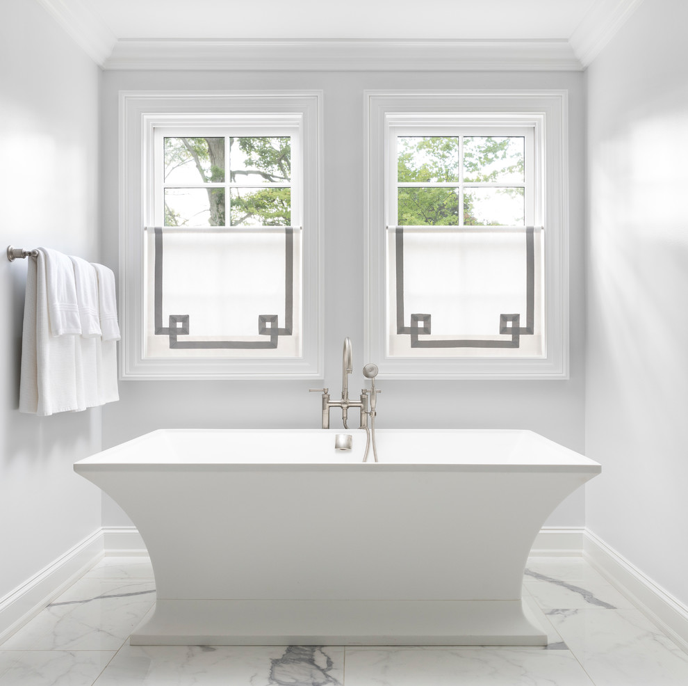 Design ideas for a medium sized traditional ensuite bathroom in Detroit with a freestanding bath, white walls, white floors, recessed-panel cabinets, white cabinets, a built-in shower, a two-piece toilet, white tiles, marble tiles, marble flooring, a built-in sink, marble worktops, a hinged door and white worktops.