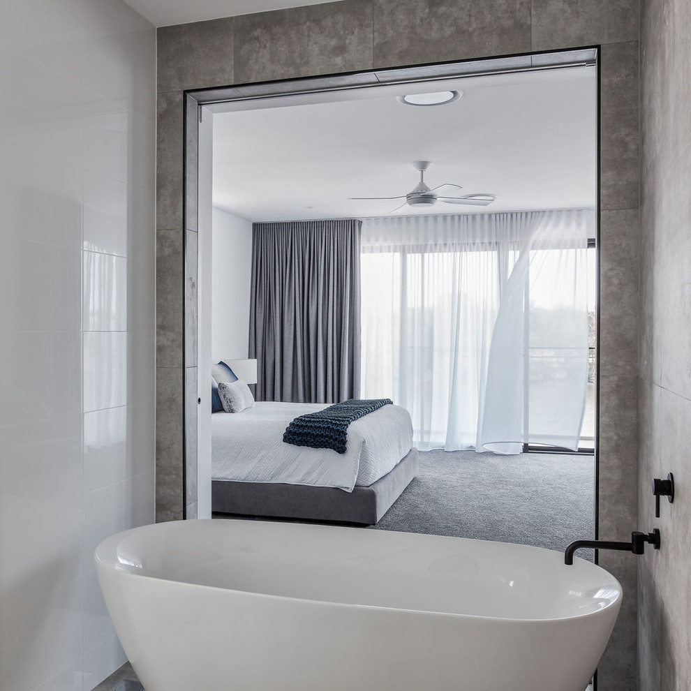Aménagement d'une salle de bain principale contemporaine avec une baignoire indépendante, un mur blanc, un sol en carrelage de porcelaine et un sol gris.