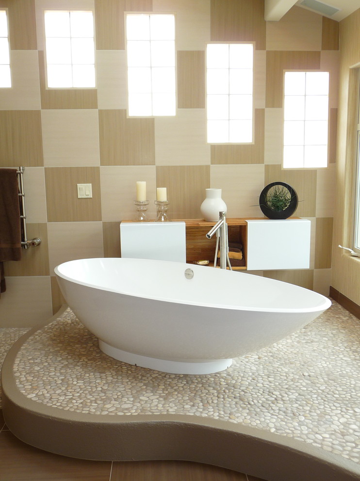 Exemple d'une salle de bain principale tendance de taille moyenne avec une baignoire indépendante, une plaque de galets, un sol en galet et un mur beige.