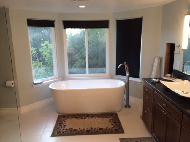 Example of a mid-sized trendy master green tile and glass sheet ceramic tile and beige floor bathroom design in San Francisco with shaker cabinets, brown cabinets, a bidet, blue walls, a trough sink and quartz countertops