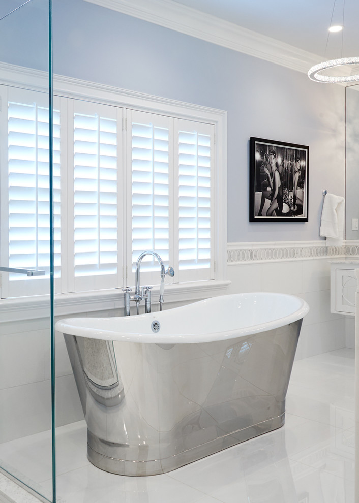 Inredning av ett klassiskt stort en-suite badrum, med möbel-liknande, vita skåp, ett fristående badkar, en öppen dusch, en vägghängd toalettstol, vit kakel, glaskakel, blå väggar, marmorgolv, ett undermonterad handfat och marmorbänkskiva