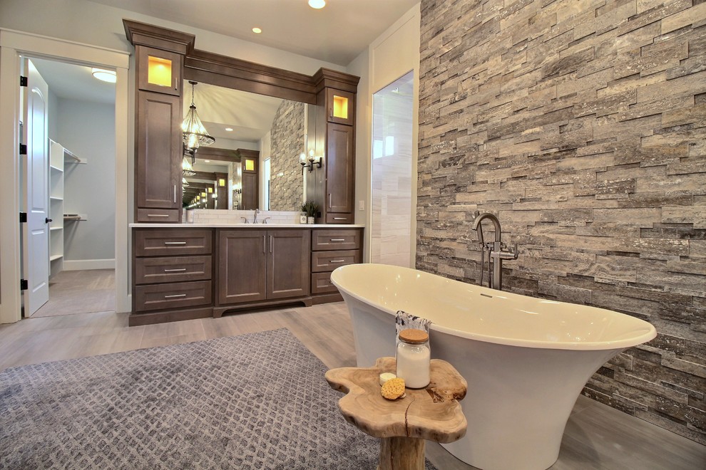 Photo of a large classic ensuite bathroom in Portland with recessed-panel cabinets, dark wood cabinets, an alcove bath, a shower/bath combination, a two-piece toilet, beige tiles, ceramic tiles, grey walls, ceramic flooring, a submerged sink, engineered stone worktops, grey floors, a sliding door and white worktops.