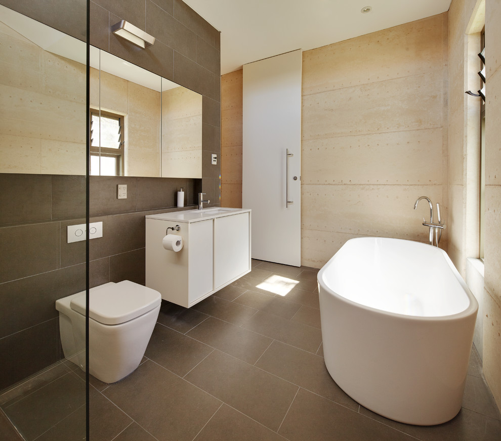 Стильный дизайн: маленькая главная ванная комната в современном стиле с врезной раковиной, столешницей из искусственного камня, отдельно стоящей ванной, открытым душем, серой плиткой, керамогранитной плиткой, разноцветными стенами, полом из керамогранита, плоскими фасадами, белыми фасадами, унитазом-моноблоком и открытым душем для на участке и в саду - последний тренд