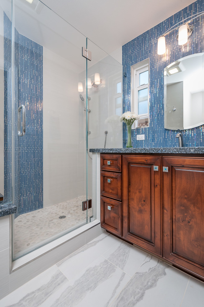 Idée de décoration pour une petite salle de bain principale marine en bois foncé avec un lavabo encastré, un placard avec porte à panneau surélevé, un plan de toilette en quartz modifié, une douche d'angle, un carrelage bleu, un carrelage en pâte de verre, un mur gris et un sol en carrelage de porcelaine.