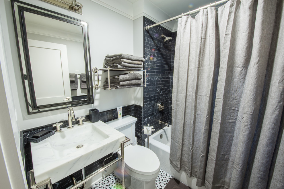 Immagine di una piccola stanza da bagno chic con lavabo a consolle, top in marmo, vasca ad alcova, vasca/doccia, WC a due pezzi, piastrelle grigie, piastrelle in pietra, pareti grigie e pavimento in marmo