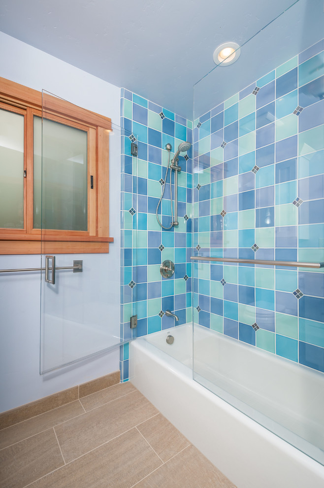Inredning av ett modernt badrum, med ett badkar i en alkov och blå kakel