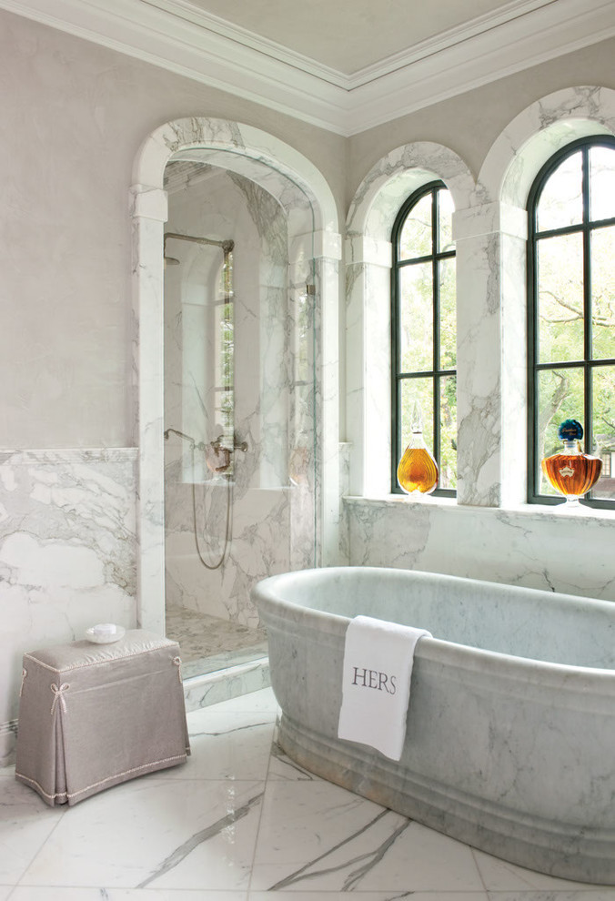 Modelo de cuarto de baño mediterráneo con bañera exenta, ducha empotrada, baldosas y/o azulejos blancos y paredes grises