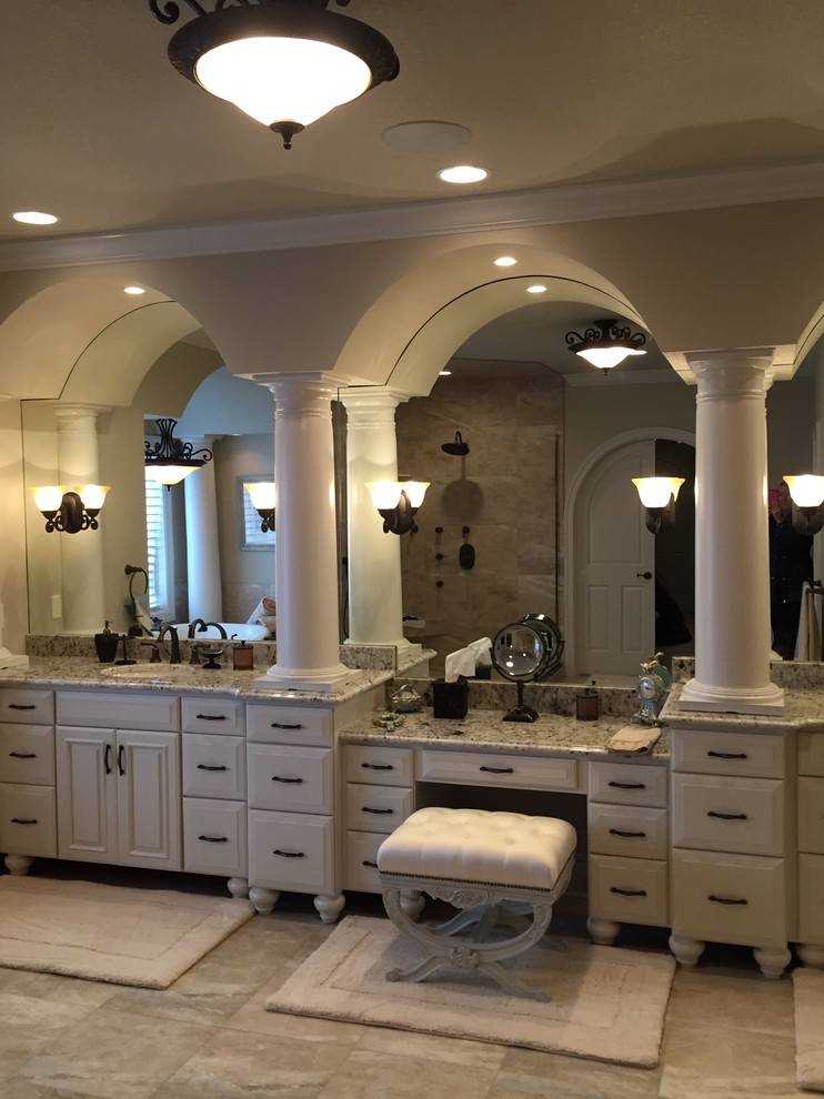 На фото: огромная главная ванная комната в викторианском стиле с фасадами с выступающей филенкой, белыми фасадами, накладной ванной, открытым душем, бежевыми стенами, врезной раковиной и столешницей из гранита с