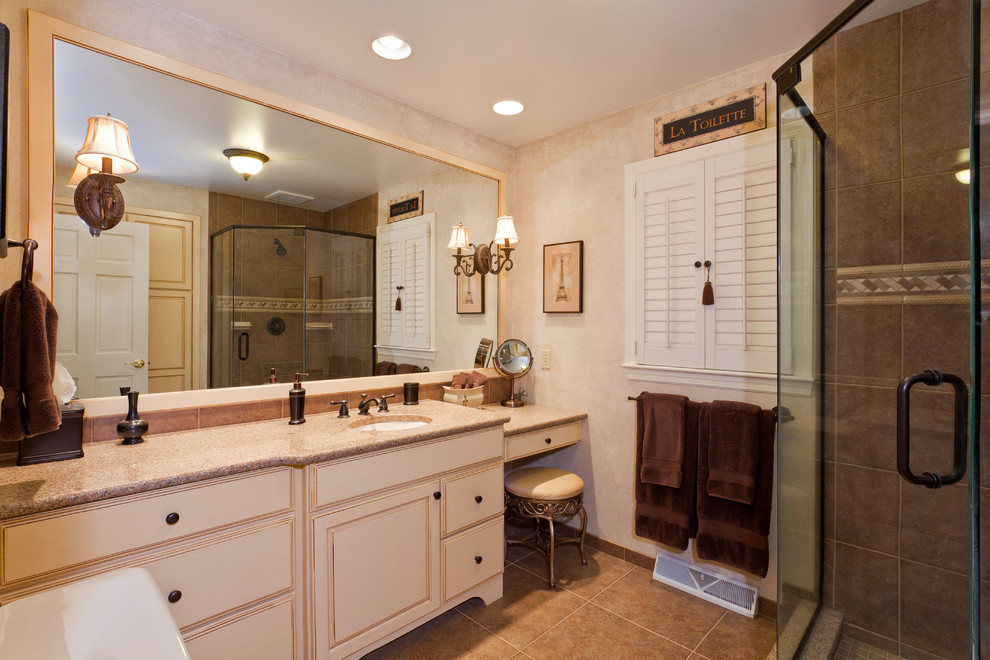 Example of a mid-sized classic 3/4 beige tile, brown tile and porcelain tile porcelain tile and brown floor corner shower design in Other with beaded inset cabinets, beige cabinets, beige walls, an undermount sink, granite countertops and a hinged shower door