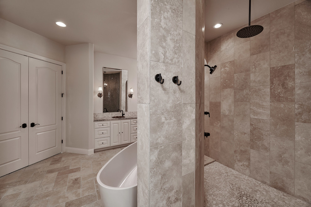 Photo of a medium sized traditional ensuite bathroom in Austin with shaker cabinets, distressed cabinets, a freestanding bath, a walk-in shower, a two-piece toilet, white tiles, ceramic tiles, beige walls, ceramic flooring, a vessel sink, granite worktops, grey floors, an open shower and multi-coloured worktops.