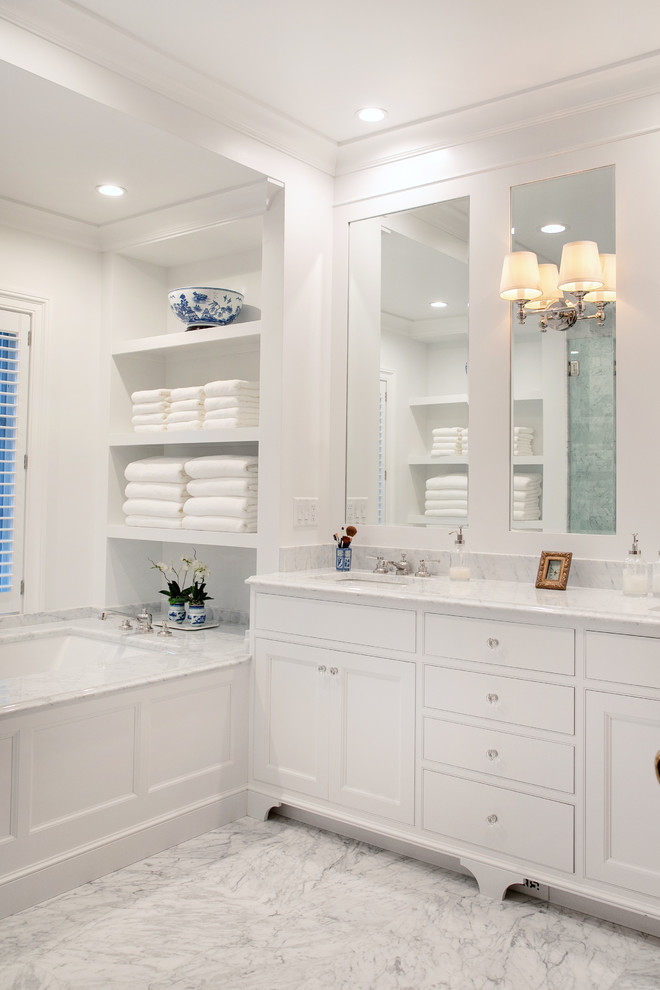 Foto på ett mellanstort vintage vit en-suite badrum, med luckor med infälld panel, vita skåp, ett undermonterat badkar, vita väggar, ett undermonterad handfat, vitt golv, en dusch i en alkov, marmorkakel, marmorgolv, marmorbänkskiva och dusch med gångjärnsdörr