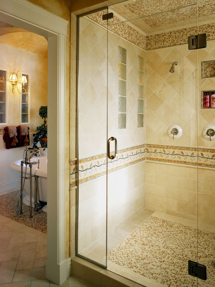 На фото: большая главная ванная комната в классическом стиле с фасадами с выступающей филенкой, белыми фасадами, отдельно стоящей ванной, двойным душем, раздельным унитазом, разноцветной плиткой, плиткой из травертина, желтыми стенами, полом из травертина, врезной раковиной, мраморной столешницей, белым полом, душем с распашными дверями и разноцветной столешницей