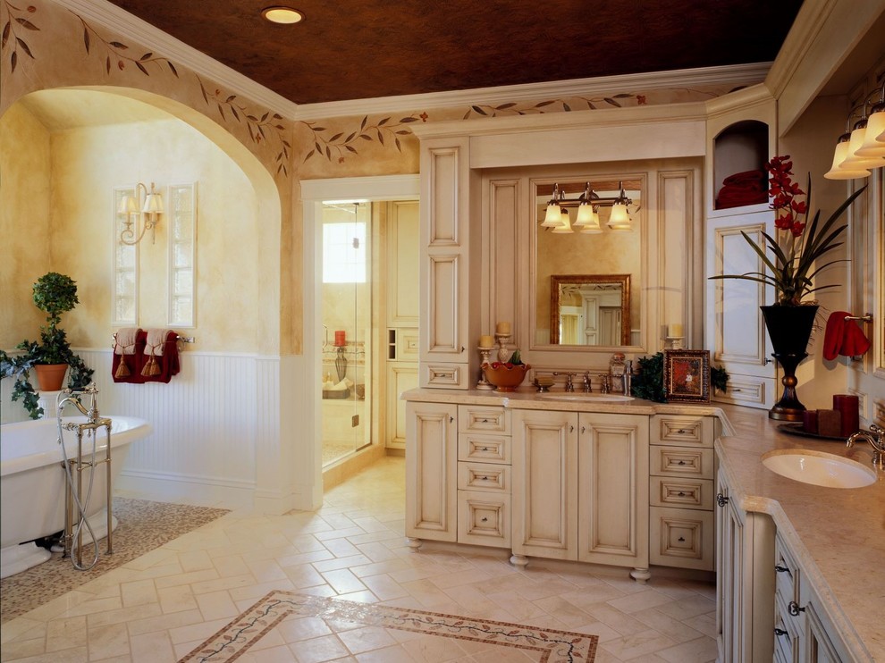 Свежая идея для дизайна: большая главная ванная комната в классическом стиле с фасадами с выступающей филенкой, белыми фасадами, отдельно стоящей ванной, двойным душем, раздельным унитазом, разноцветной плиткой, плиткой из травертина, желтыми стенами, полом из травертина, врезной раковиной, мраморной столешницей, белым полом, душем с распашными дверями и разноцветной столешницей - отличное фото интерьера