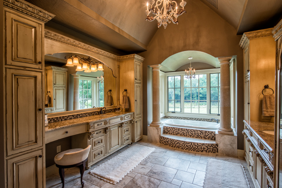 На фото: огромная главная ванная комната в классическом стиле с фасадами островного типа, бежевыми фасадами, накладной ванной, керамической плиткой, бежевыми стенами, полом из керамической плитки, врезной раковиной и столешницей из гранита с