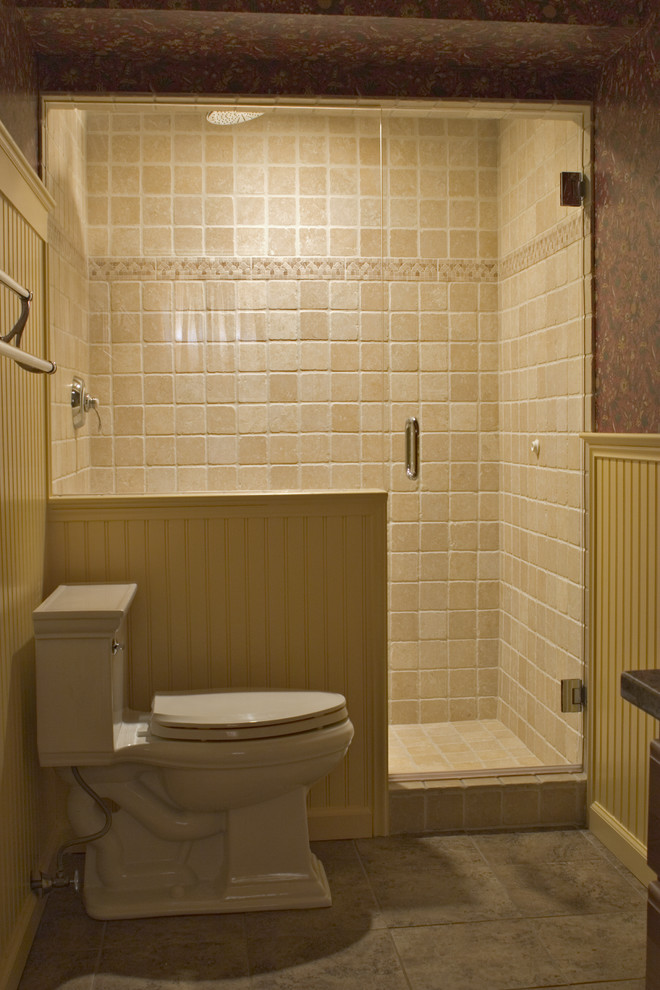 ブリッジポートにあるお手頃価格の中くらいなカントリー風のおしゃれな浴室 (アンダーカウンター洗面器、中間色木目調キャビネット、御影石の洗面台、アルコーブ型シャワー、分離型トイレ、ベージュのタイル、石タイル、黄色い壁、磁器タイルの床) の写真