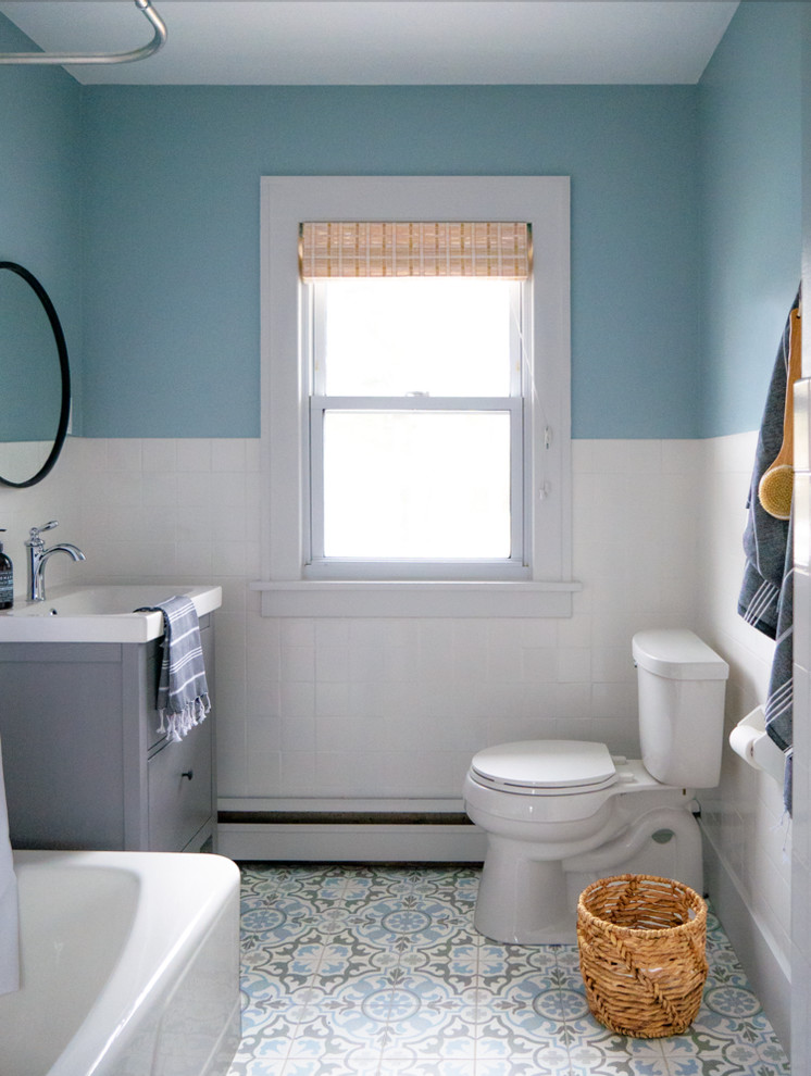 Idéer för ett nordiskt vit badrum med dusch, med släta luckor, grå skåp, ett hörnbadkar, en dusch/badkar-kombination, en toalettstol med separat cisternkåpa, vit kakel, blå väggar, ett integrerad handfat, flerfärgat golv och dusch med duschdraperi
