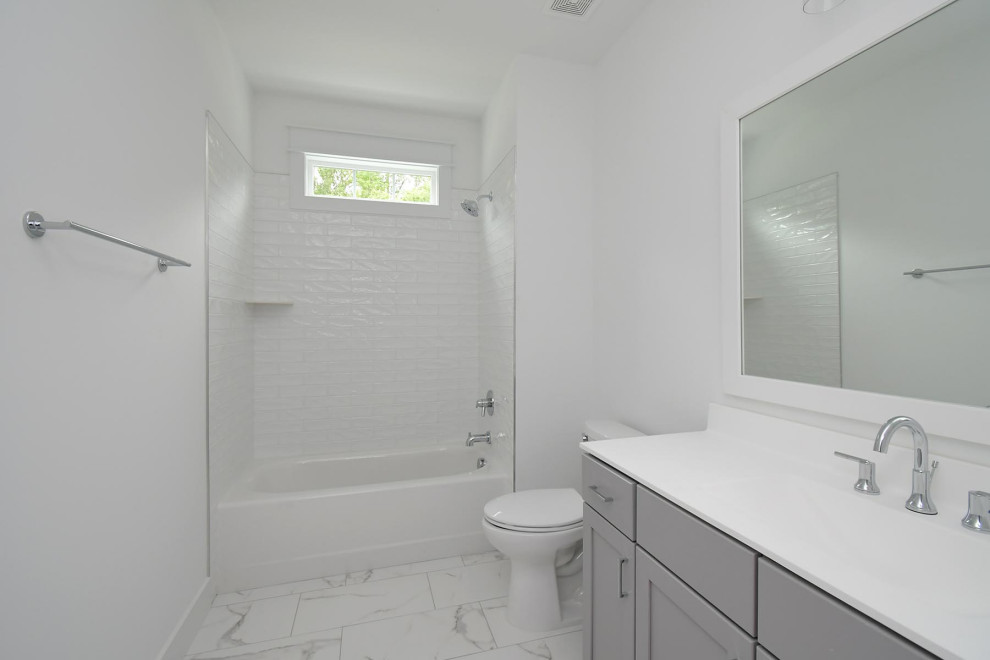 Idéer för att renovera ett stort vintage vit vitt badrum för barn, med skåp i shakerstil, grå skåp, ett badkar i en alkov, en dusch/badkar-kombination, en toalettstol med separat cisternkåpa, vit kakel, keramikplattor, vita väggar, klinkergolv i keramik, ett integrerad handfat, marmorbänkskiva, flerfärgat golv och dusch med duschdraperi