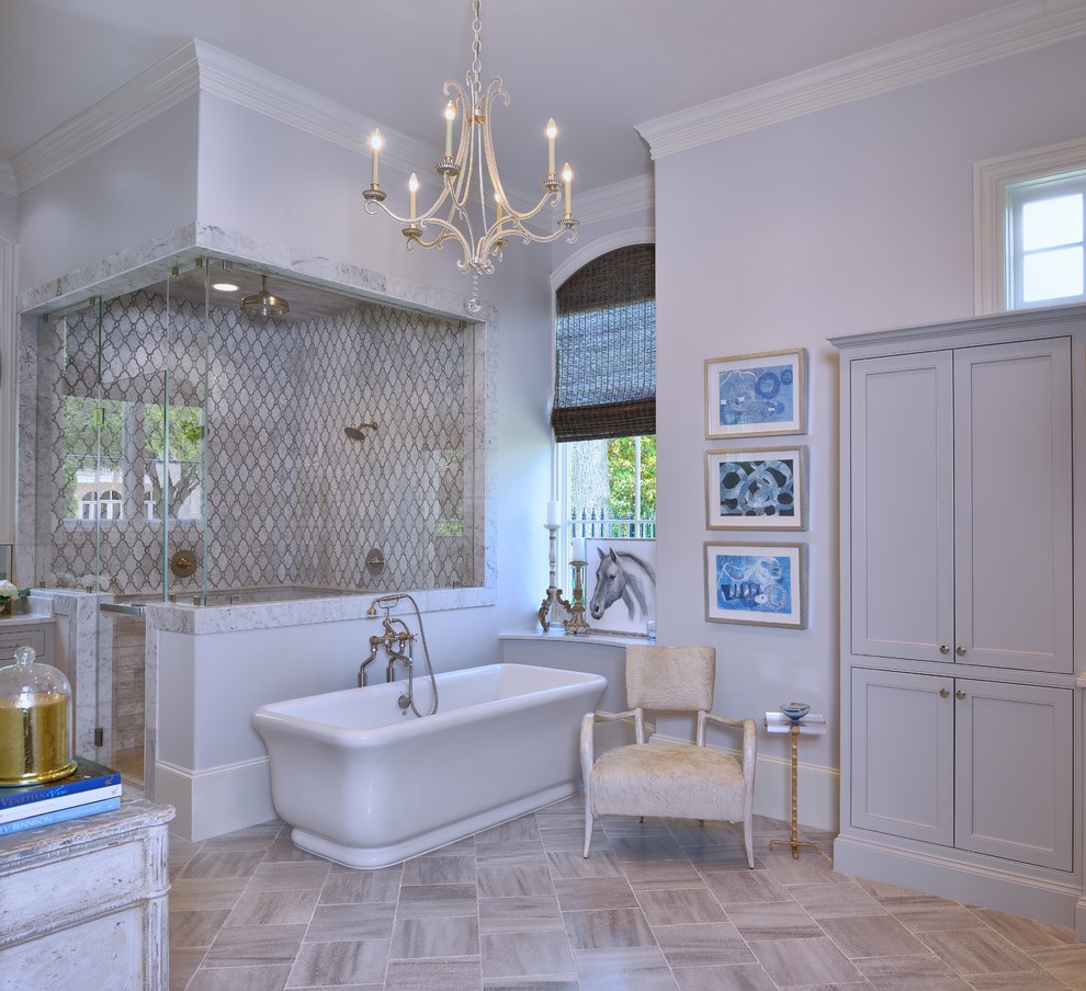 Esempio di una stanza da bagno padronale mediterranea con vasca freestanding, doccia ad angolo, piastrelle grigie, piastrelle di marmo, pareti grigie, pavimento grigio e porta doccia a battente