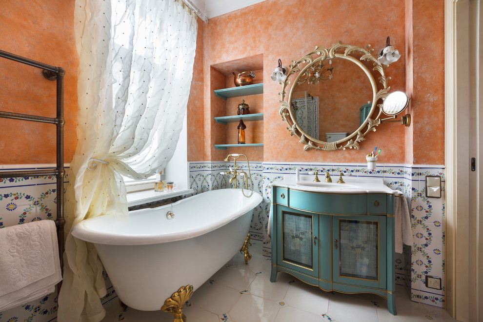 Idéer för att renovera ett litet vintage en-suite badrum, med ett fristående badkar, vit kakel, flerfärgad kakel, keramikplattor, orange väggar, klinkergolv i porslin, luckor med infälld panel och blå skåp