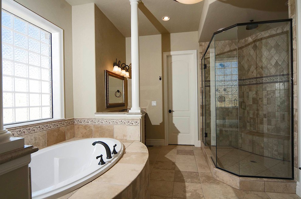 Inspiration for a large mediterranean master beige tile and ceramic tile travertine floor and beige floor bathroom remodel in Denver with raised-panel cabinets, dark wood cabinets, beige walls, an undermount sink, granite countertops, a hinged shower door and beige countertops