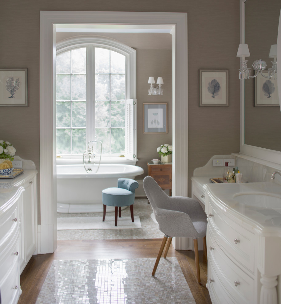 Ejemplo de cuarto de baño principal clásico con armarios con paneles empotrados, puertas de armario blancas, bañera exenta, lavabo bajoencimera y paredes marrones