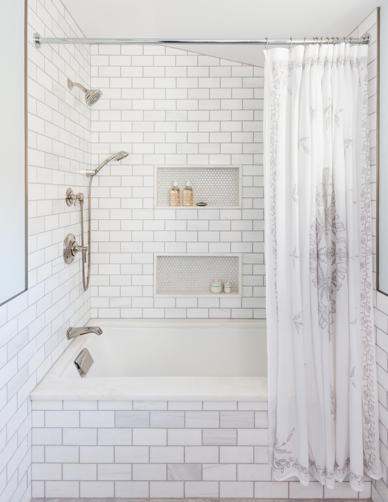 Inredning av ett lantligt badrum, med ett undermonterat badkar, en dusch/badkar-kombination, vit kakel, tunnelbanekakel och grå väggar