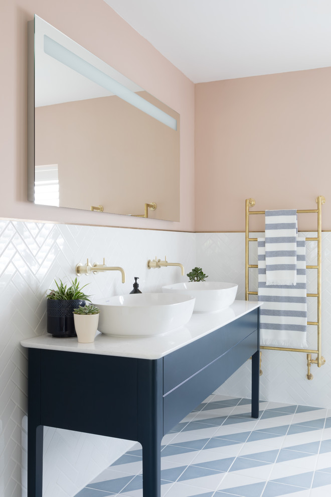 Maritimes Badezimmer En Suite mit blauen Schränken, weißen Fliesen, rosa Wandfarbe, Aufsatzwaschbecken, buntem Boden, weißer Waschtischplatte und flächenbündigen Schrankfronten in Surrey