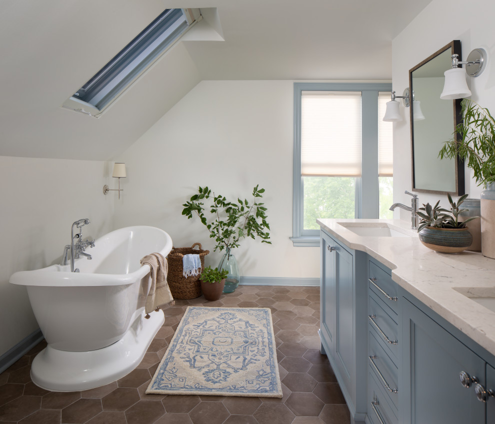 Idée de décoration pour une salle de bain champêtre avec un placard avec porte à panneau encastré, des portes de placard bleues, une baignoire indépendante, un mur blanc, un lavabo encastré, un sol marron, un plan de toilette blanc, meuble double vasque et meuble-lavabo encastré.