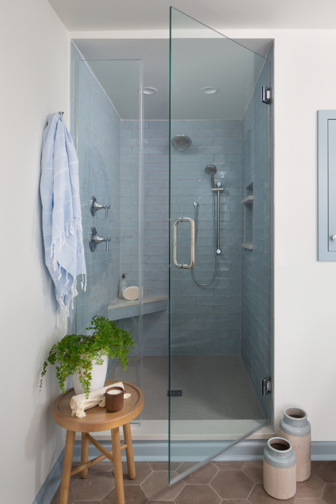 Foto di una stanza da bagno tradizionale con doccia alcova, piastrelle blu, pareti bianche, pavimento marrone e porta doccia a battente