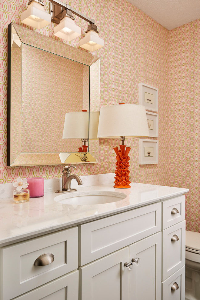 Foto de cuarto de baño clásico de tamaño medio con armarios con paneles lisos, puertas de armario blancas, paredes rosas, suelo de madera oscura, lavabo bajoencimera, encimera de cuarzo compacto y suelo marrón