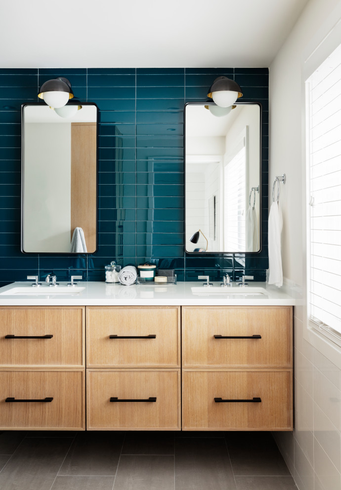 This is an example of a medium sized contemporary shower room bathroom in New York with recessed-panel cabinets, blue tiles, glass tiles, white walls, porcelain flooring, a submerged sink, quartz worktops, grey floors, white worktops and light wood cabinets.