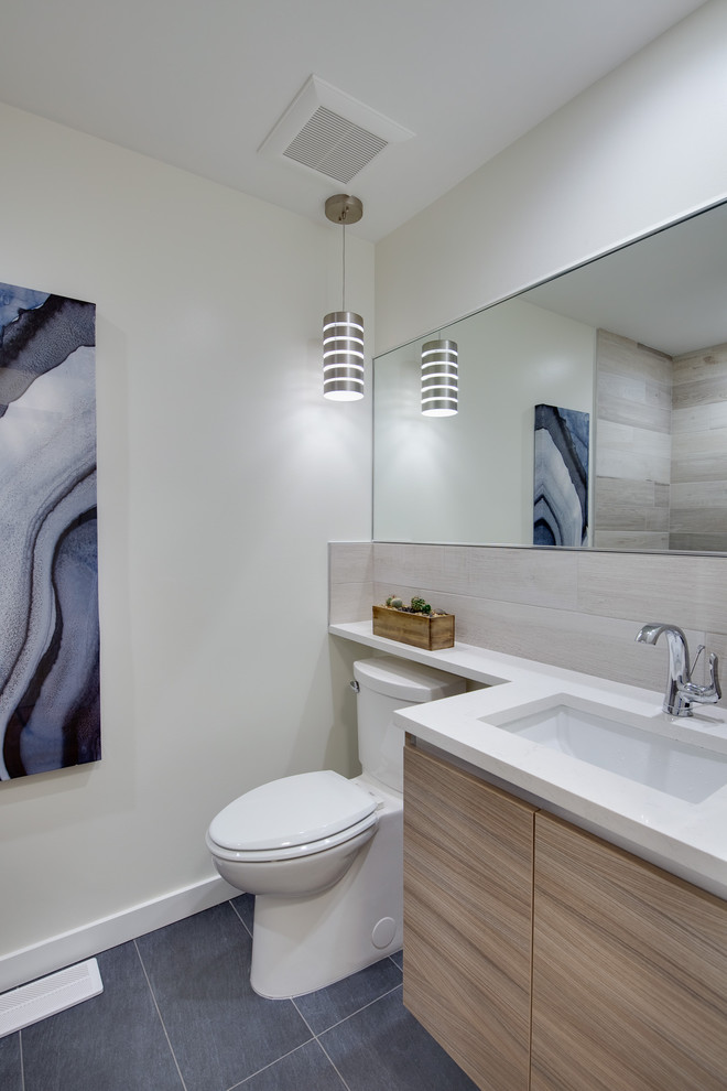 Mid-sized transitional 3/4 beige tile and porcelain tile porcelain tile doorless shower photo in Seattle with flat-panel cabinets, light wood cabinets, a one-piece toilet, white walls, an undermount sink and quartz countertops