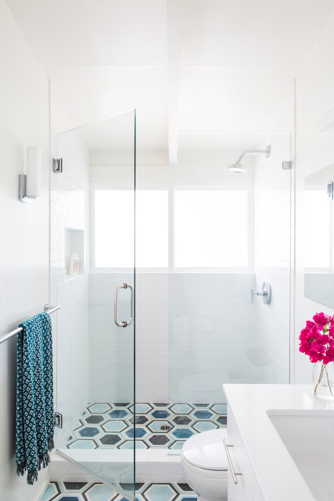 Пример оригинального дизайна: главная ванная комната среднего размера в стиле модернизм с плоскими фасадами, белыми фасадами, отдельно стоящей ванной, душем в нише, унитазом-моноблоком, синей плиткой, цементной плиткой, белыми стенами, бетонным полом, врезной раковиной и столешницей из искусственного кварца