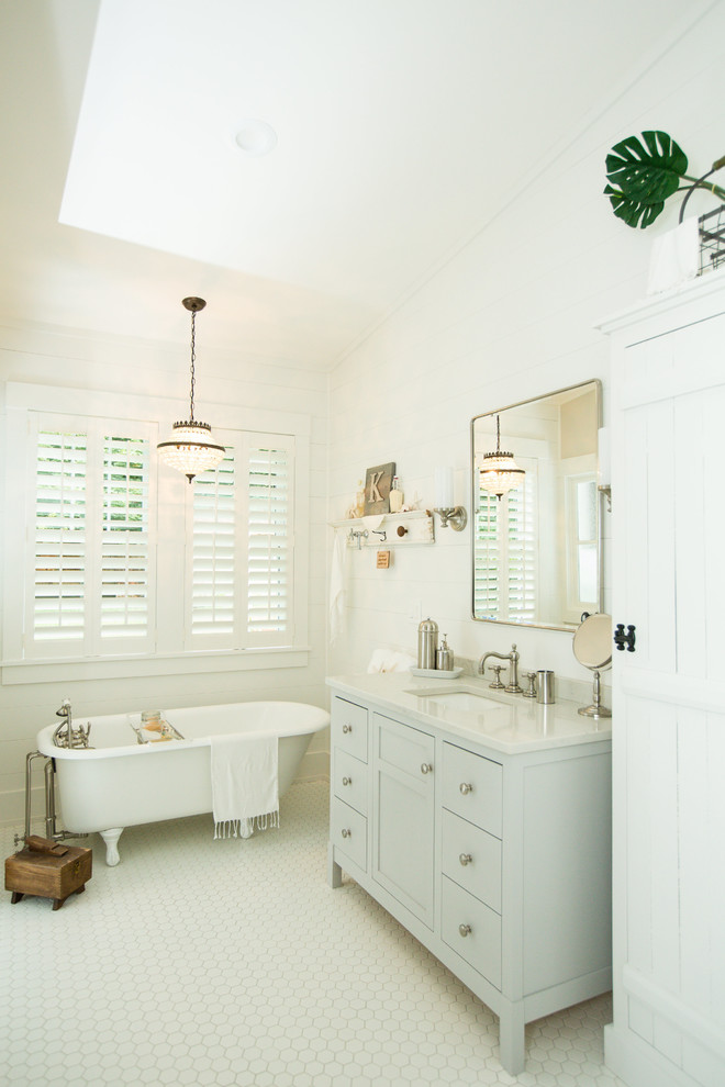 Idée de décoration pour une petite salle de bain principale champêtre avec un mur blanc, un plan de toilette gris, des portes de placard grises, une baignoire sur pieds, un lavabo encastré, un sol blanc et un placard à porte shaker.