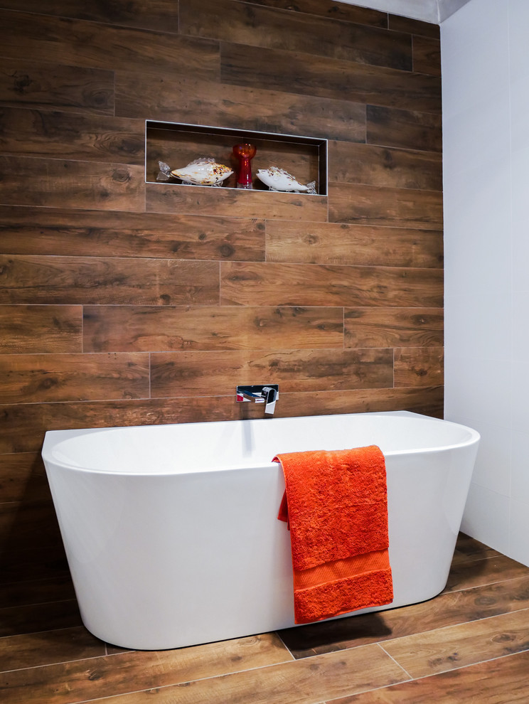 Inspiration för ett stort funkis badrum, med ett fristående badkar, en toalettstol med hel cisternkåpa och brunt golv