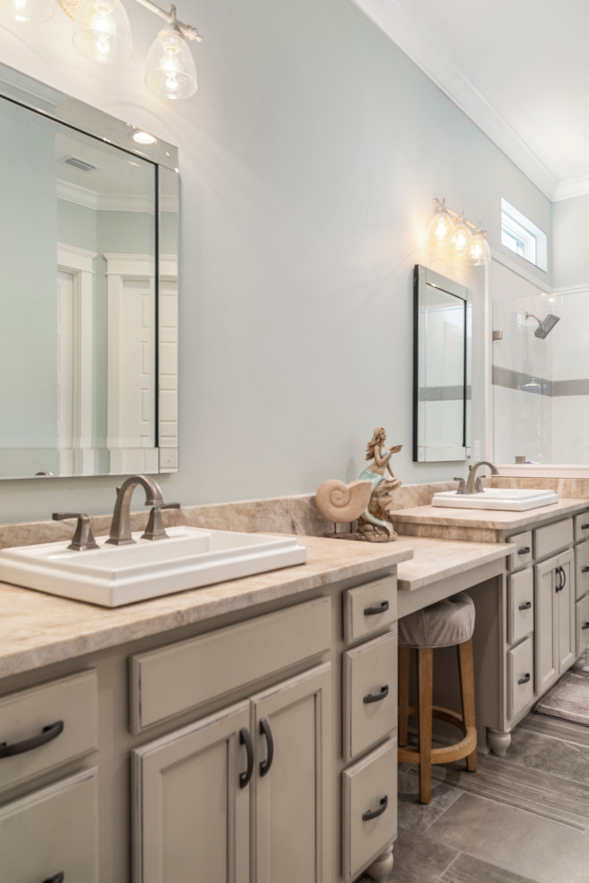 Example of a mid-sized arts and crafts porcelain tile and gray floor corner shower design in Birmingham with recessed-panel cabinets, beige cabinets, blue walls, granite countertops and beige countertops