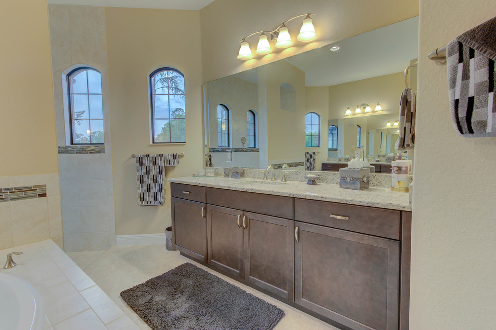 Imagen de cuarto de baño principal tradicional de tamaño medio con armarios con paneles lisos, puertas de armario marrones y encimera de granito