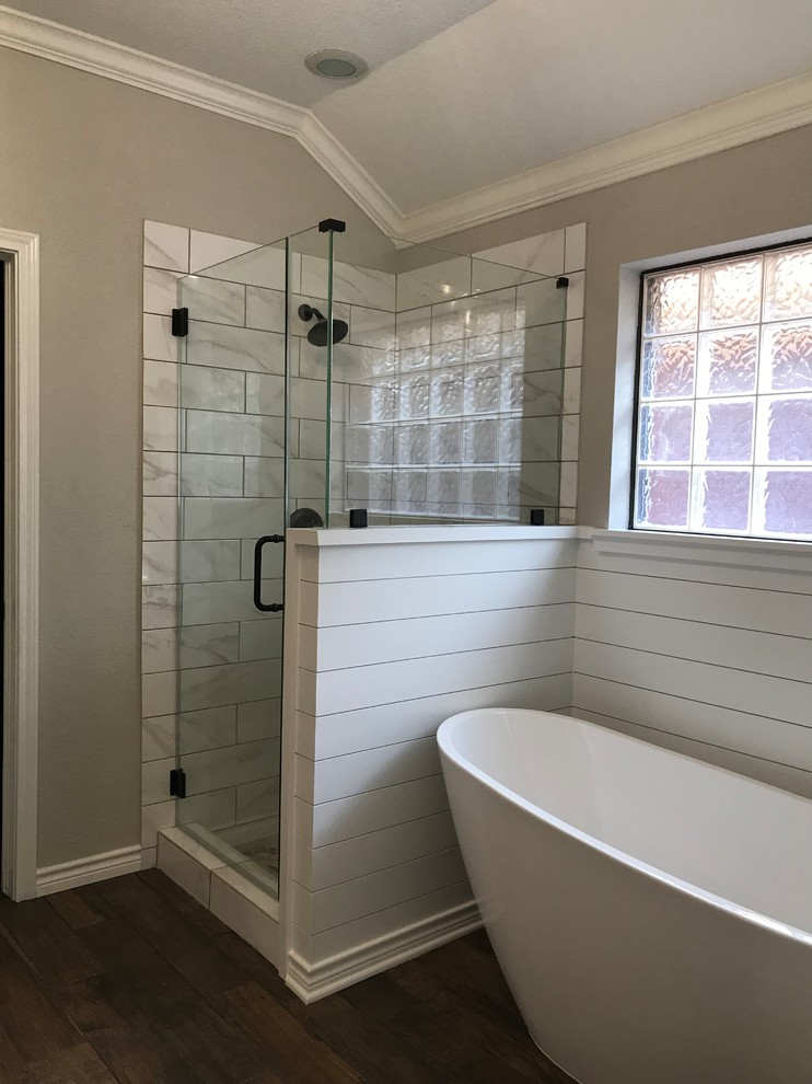 Bild på ett mellanstort lantligt en-suite badrum, med vita skåp, ett fristående badkar, en dusch i en alkov, vit kakel, keramikplattor, grå väggar, klinkergolv i porslin, ett undermonterad handfat, marmorbänkskiva, brunt golv och dusch med gångjärnsdörr