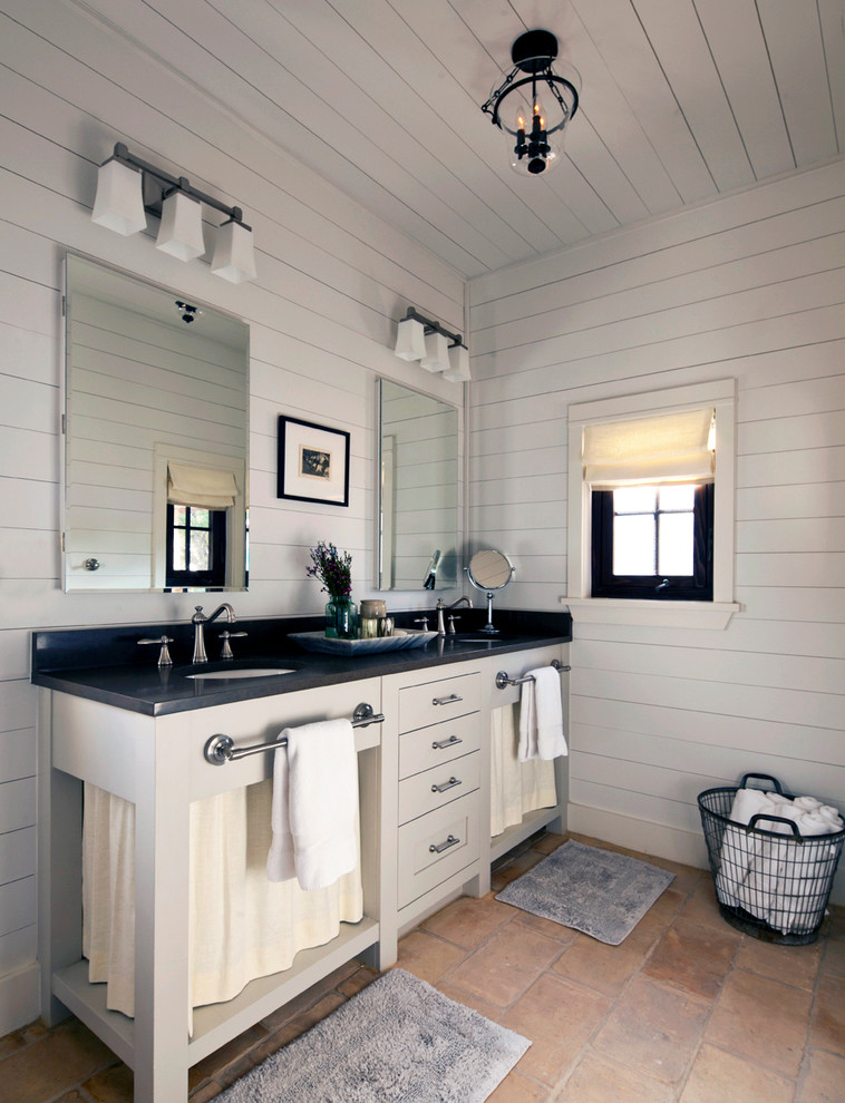 オースティンにあるカントリー風のおしゃれな浴室 (グレーのキャビネット、白い壁、アンダーカウンター洗面器、フラットパネル扉のキャビネット) の写真