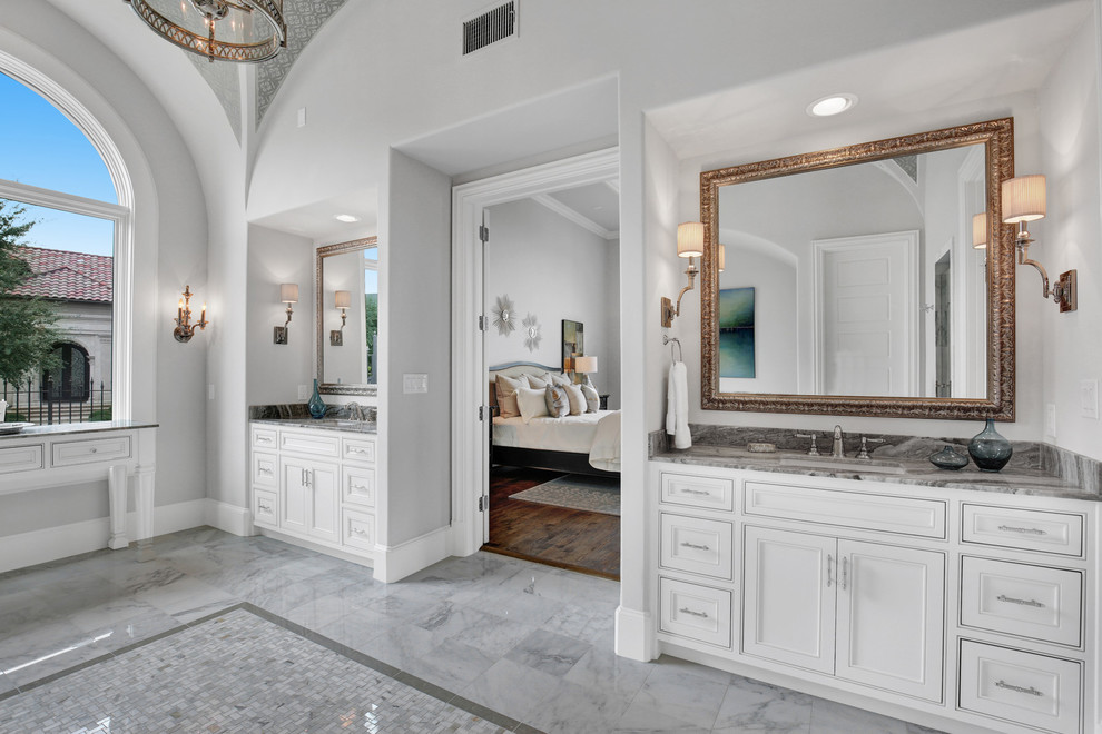 Inspiration for a large mediterranean ensuite bathroom in Dallas with beaded cabinets, white cabinets, a built-in bath, an alcove shower, grey tiles, marble tiles, grey walls, marble flooring, a submerged sink, granite worktops, white floors and a hinged door.