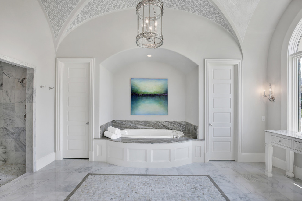 Inspiration for a large mediterranean ensuite bathroom in Dallas with beaded cabinets, white cabinets, a built-in bath, an alcove shower, grey tiles, marble tiles, grey walls, marble flooring, granite worktops, white floors and a hinged door.