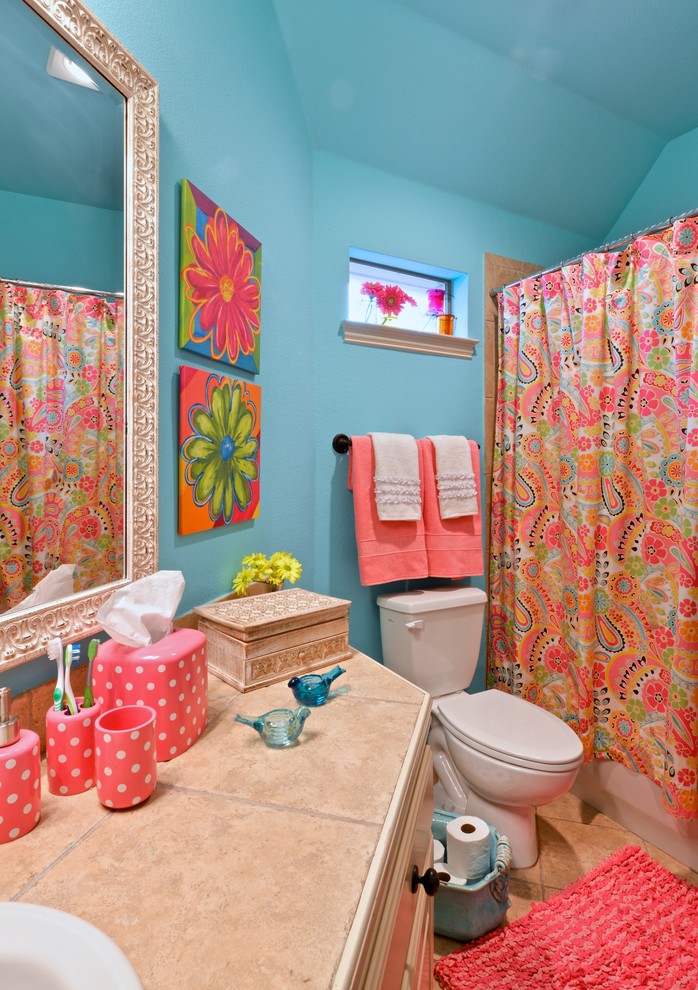 This is an example of a medium sized eclectic family bathroom in Dallas with a built-in sink, white cabinets, tiled worktops, a shower/bath combination, beige tiles, stone tiles, blue walls, porcelain flooring, an alcove bath and a shower curtain.