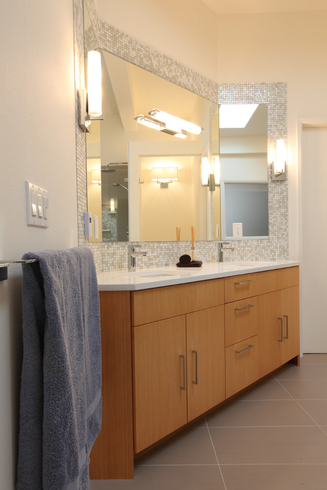 Стильный дизайн: большая главная ванная комната в стиле ретро с плоскими фасадами, светлыми деревянными фасадами, полновстраиваемой ванной, душевой комнатой, унитазом-моноблоком, серой плиткой, керамогранитной плиткой, белыми стенами, полом из керамогранита, врезной раковиной и столешницей из искусственного кварца - последний тренд