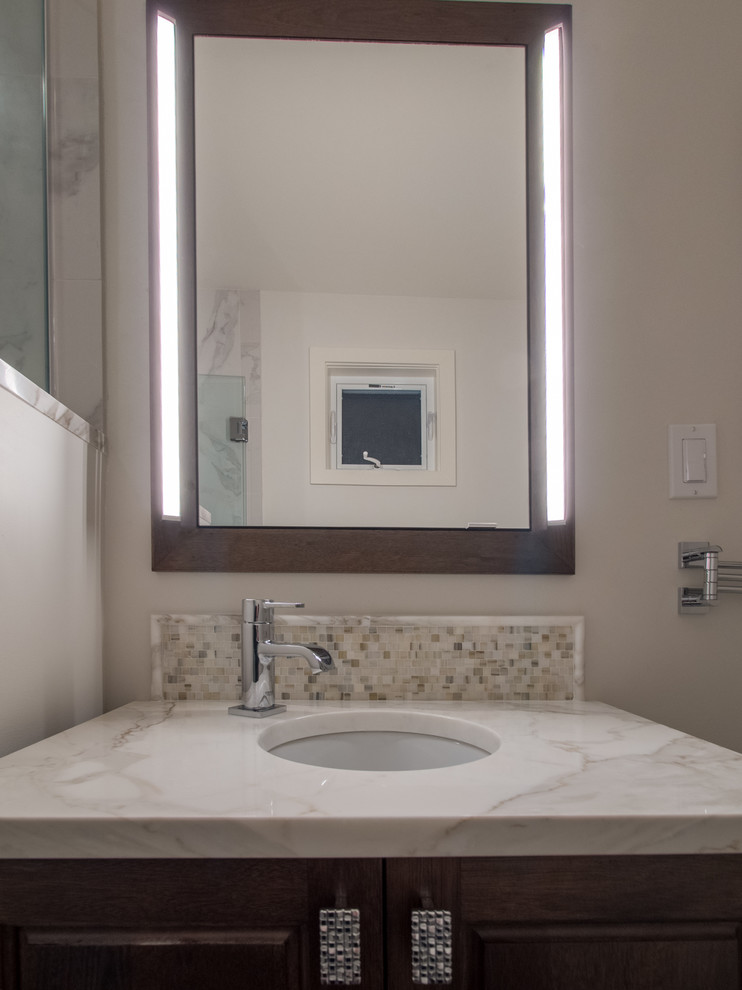 Cette image montre une petite salle de bain design en bois brun avec un placard en trompe-l'oeil, WC séparés, un carrelage gris, des carreaux de porcelaine, un mur blanc, un sol en carrelage de porcelaine, un lavabo encastré, un plan de toilette en marbre, un sol marron, une cabine de douche à porte battante, un plan de toilette blanc, meuble simple vasque et meuble-lavabo suspendu.