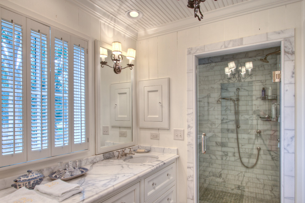 Cette photo montre une salle de bain nature avec un plan de toilette en marbre et du carrelage en marbre.