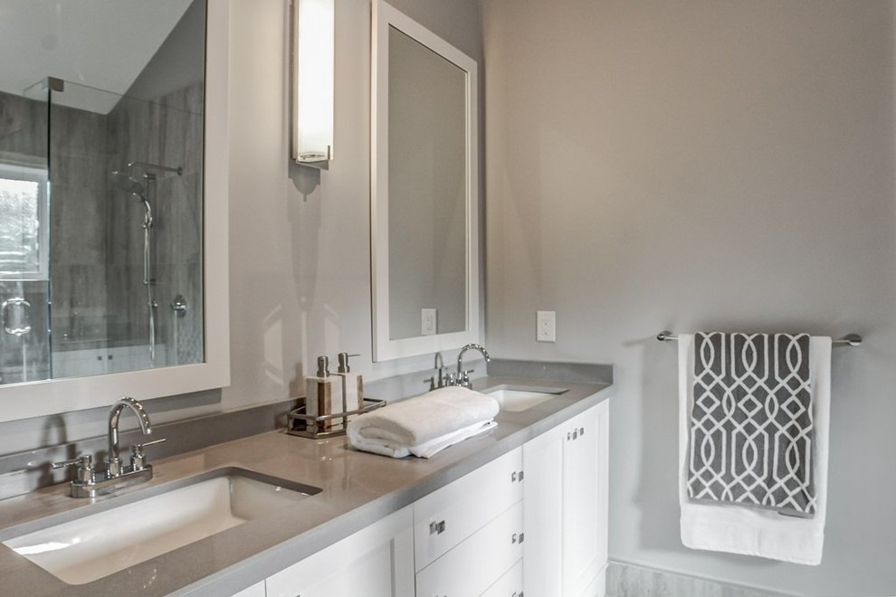 Example of a mid-sized transitional master gray tile and porcelain tile porcelain tile corner shower design in Toronto with shaker cabinets, white cabinets, a one-piece toilet, gray walls, an undermount sink and quartz countertops